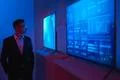 The businessman standing near screens in the dark room Photo
