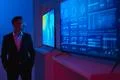 The businessman standing near screens with graphs Photo
