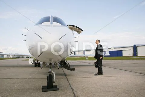 Businessman Standing Next To An Airplane