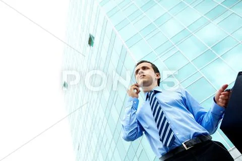 Businessman standing by office building Stock Photos