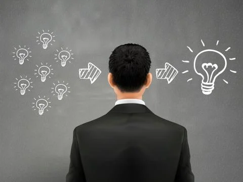 Businessman stands in front of bulbs elements 스톡 일러스트