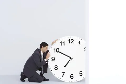 Businessman staring at oversized clock Stock Photos