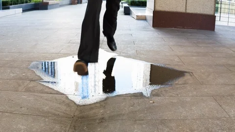 Businessman stepping over a puddle Video stock 104070774