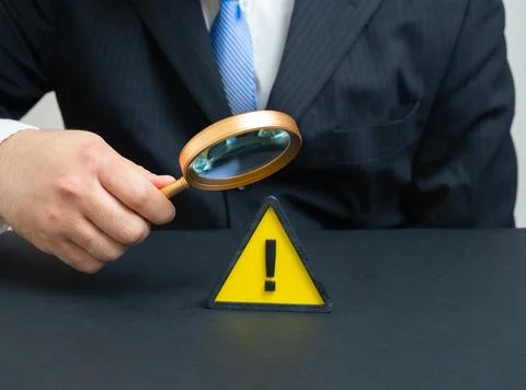 A businessman studies a problem. A warning sign signals a businessman in im.. Stock Photos