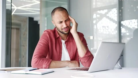 Businessman suffering from headache while working on laptop while sitting  Stock Footage 311623567