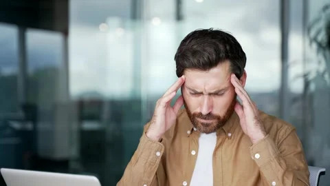 Businessman suffering from headache while working on laptop sitting  Video stock 325513095