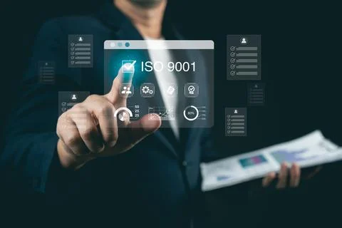 Businessman in suit interacts with digital interface showcasing ISO 9001 qu.. 写真素材