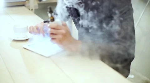 Businessman in a suit reading on tablet with an e-cigarette vape Stock Footage 56891909