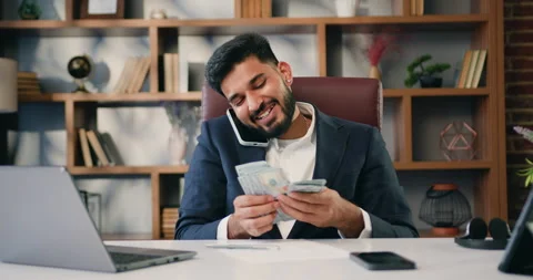 Businessman in suit is talking on the phone and counting dollar bills while Stock Footage 220300341