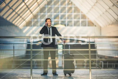 The businessman with a suitcase phone in the business center Stock Photos