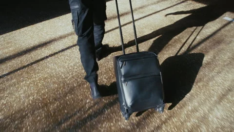 Businessman with a suitcase walking through an empty parking lot 库存影片 335474282