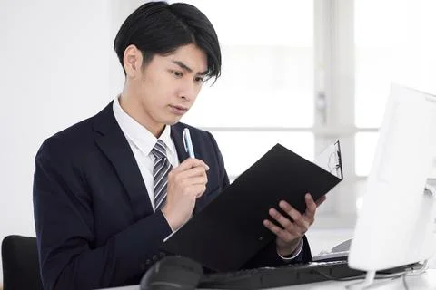 A businessman summarizes data with a serious expression. Stock Photos