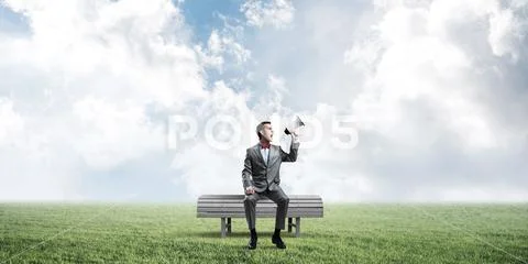 Businessman in summer park announcing something in loudspeaker Stock Photos