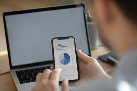Businessman synchronize information using laptop and smartphone with financial Stock Photos