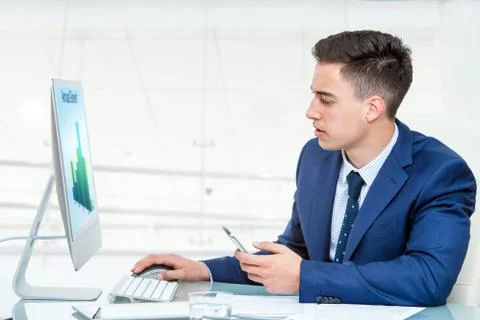 Businessman synchronizing smart phone with computer Stock Photos