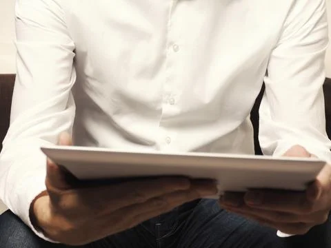Businessman with a tablet computer reading an ebook, selective focus on man Stock Photos