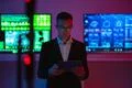 The businessman with a tablet standing on screens background Photo