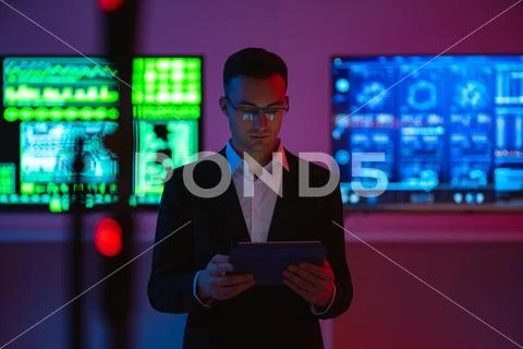The businessman with a tablet standing on screens background Stock Photos