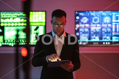 The businessman with a tablet standing on screens background Stock Photos