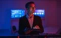 The businessman with a tablet working in a room with screens Photo