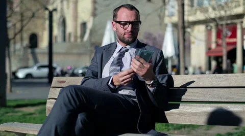Businessman taking baguette using cellphone on street bench. Stock-Footage 36717136