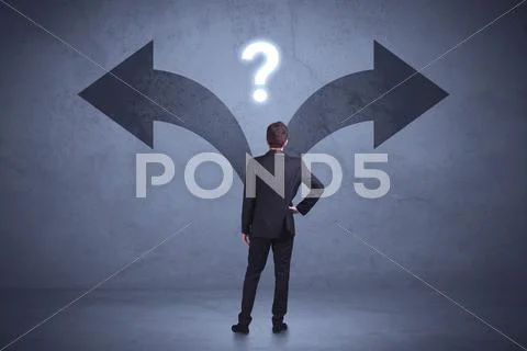 Businessman taking a decision while looking at arrows on the wall concept Stock Photos
