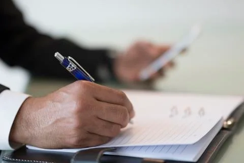 Businessman taking notes in book Stock Photos