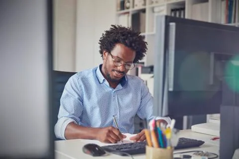 Businessman taking notes at computer in office 스톡 사진