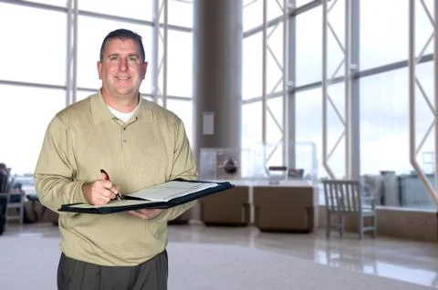 Businessman taking notes in lobby Stock Photos