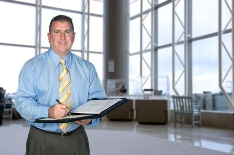 Businessman taking notes in lobby Stock Photos