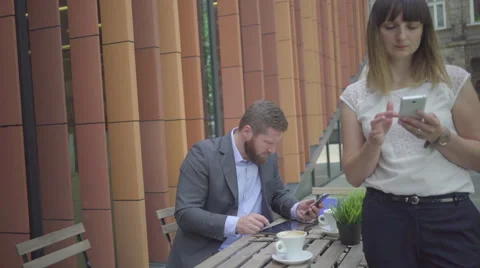 Businessman taking notes from smarthone to tablet, outdoor. Steadicam shot. Vídeos de archivo 65333495