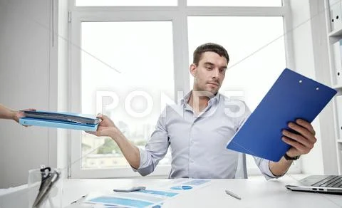 Businessman taking papers from secretary in office Stock Photos