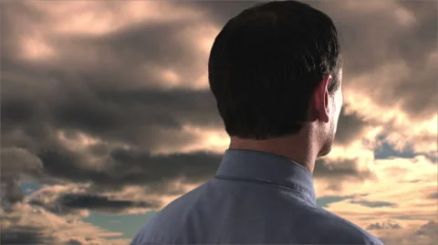 Businessman talking on a cellular phone, clouds in background. Stock Footage 43679855