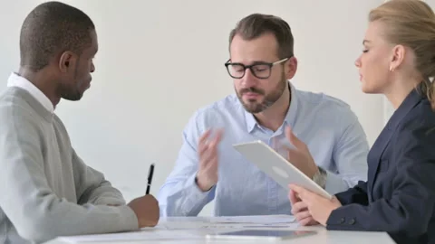 Businessman Talking to Colleagues using Tablet and Taking Notes Stock Footage 163446088