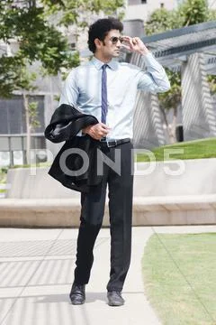 Businessman talking on a mobile phone at poolside Stock Photos