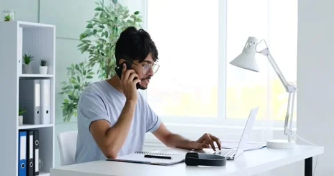 Businessman talking on mobile phone while working at office 動画素材 168034575