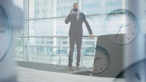 Businessman talking on phone with multiple clocks animation over office Stock Footage 306820072