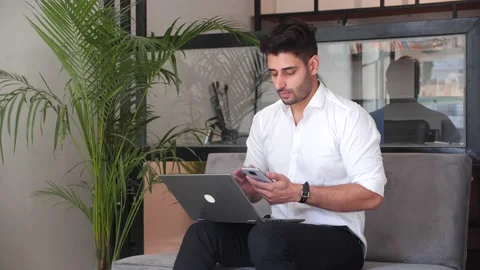 Businessman talking  phone at office while working on laptop. Видео 146204403