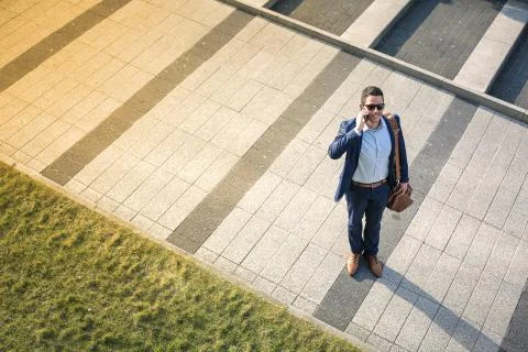 Businessman talking at the phone while walking in the street Stock Photos