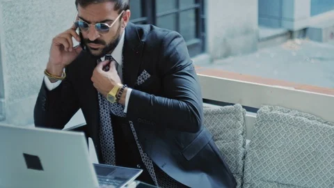 Businessman talking on the phone while working on the laptop 스톡 동영상 96297858