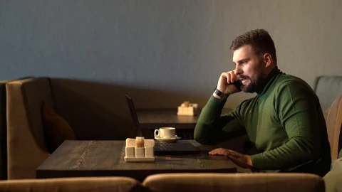 Businessman talking phone while working with his laptop in the cafe Stock Footage 126029663