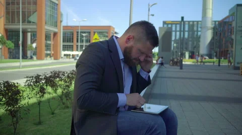 Businessman talking by smartphone, checks data on tablet, steadicam. Vidéo 66297533