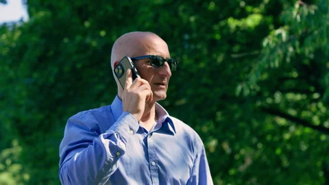 Businessman Talking on Smartphone Looking to Camera Outdoors 库存影片 339032888