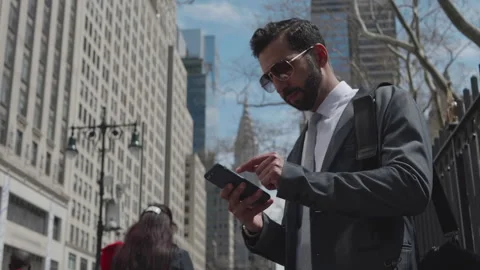 Businessman texting on smartphone while walking in busy city street Stock Footage 312686097