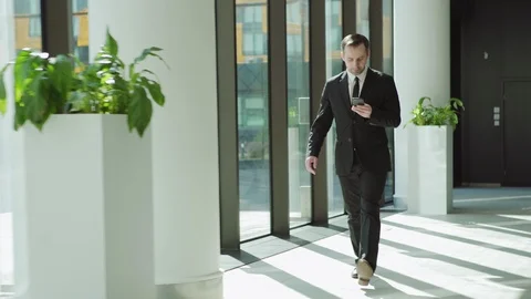Businessman texting while walking in hall Video stock 108680251