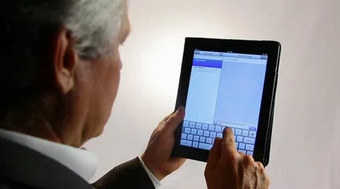 BUSINESSMAN TEXTS ON A TABLET COMPUTER Stock Footage 12155116