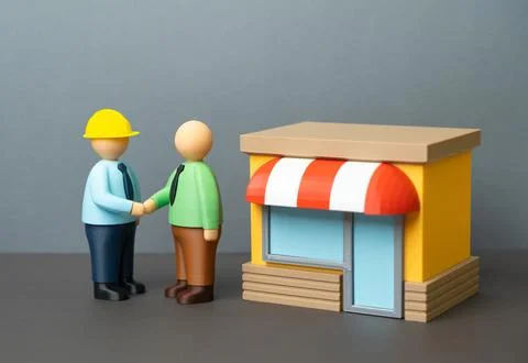 A businessman thanks a builder for completing the construction of his busines Stock Photos