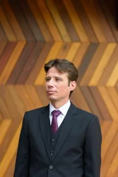 Businessman thinking against zigzag patterned wooden wall outdoors Foto stock