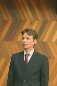 Businessman thinking against zigzag patterned wooden wall Foto stock