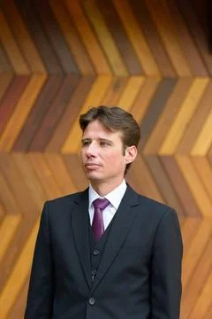 Businessman thinking against zigzag patterned wooden wall outdoors Busines... Foto stock